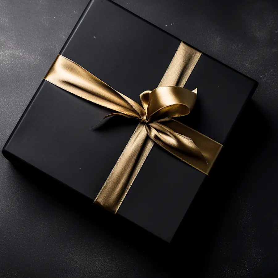 A black gift box tied with a wide gold ribbon.